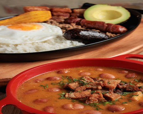 Dining table with traditional Colombian food, rice, beans and vegetables